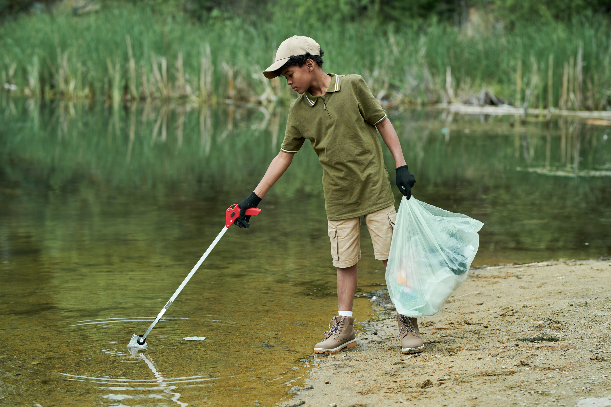 Boy cleaning the lake from garbage