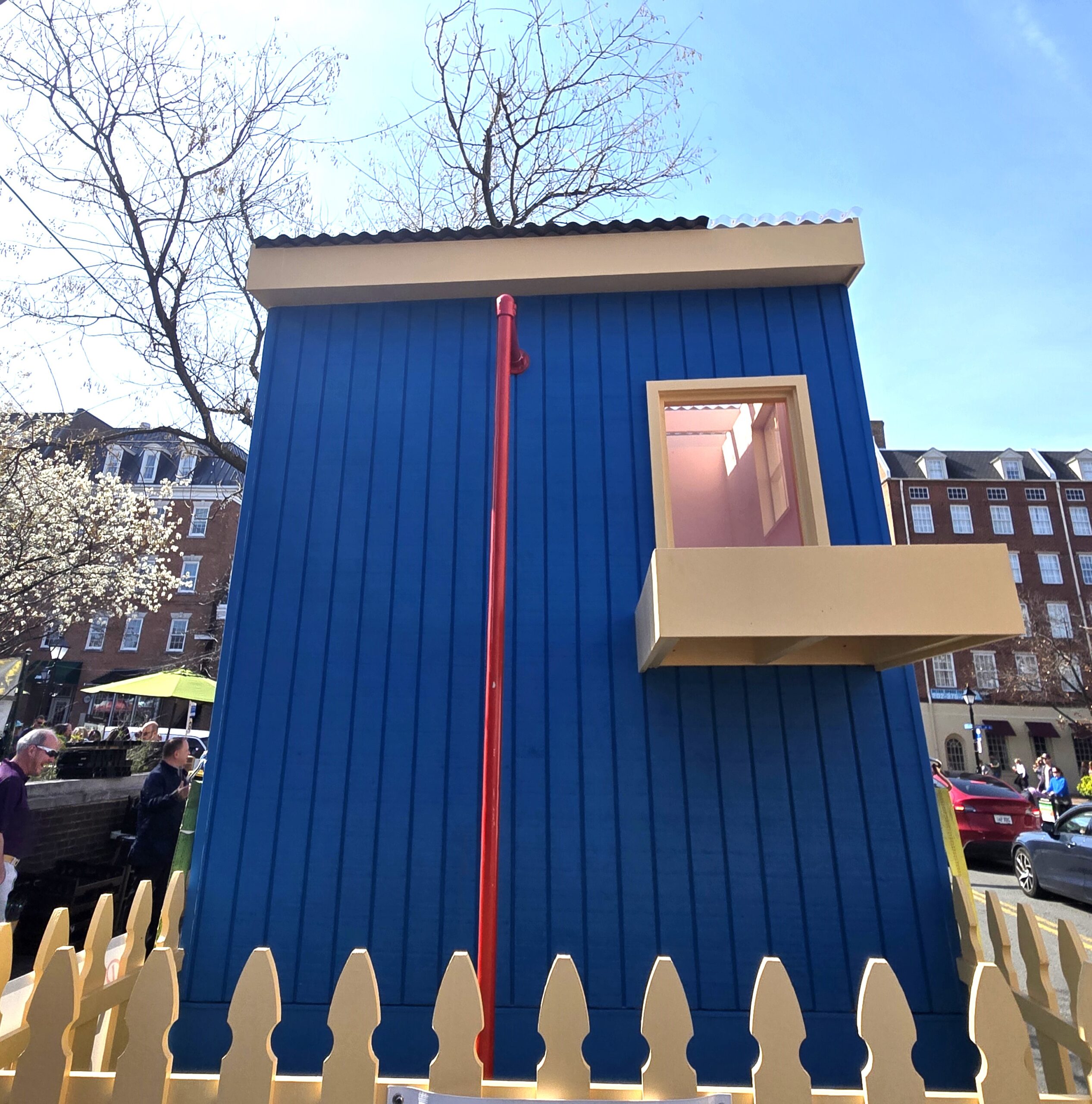 Wooden structure pained all blue with one window and a window box