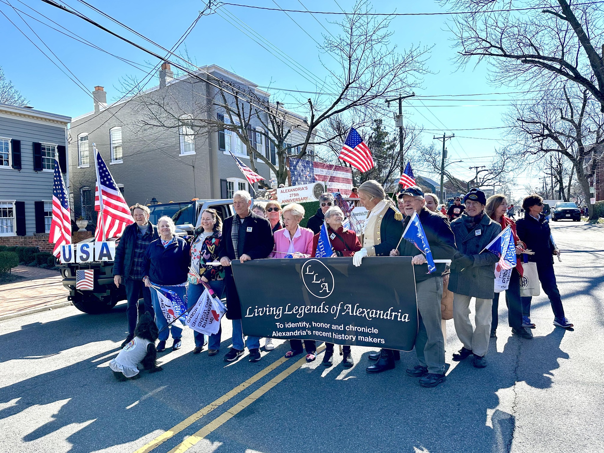 Group of people carrying the Living Legends of Alexandria parade banner