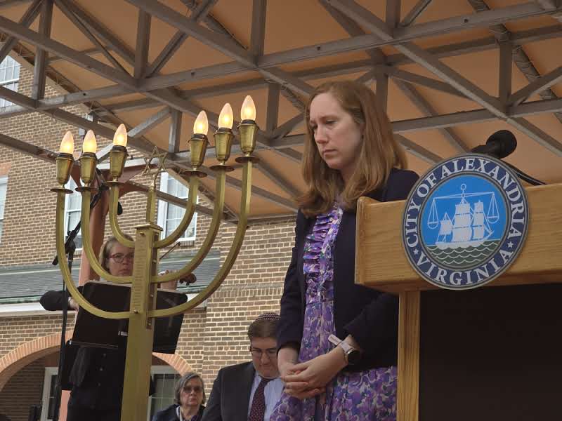 Woman looking solemnly at menorah