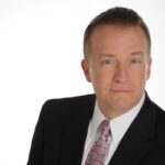 Middle aged executive in coat and tie headshot