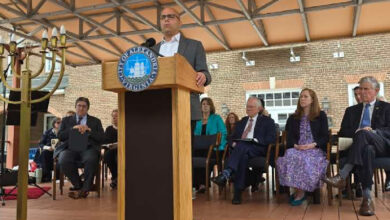 Man at podium with menorah