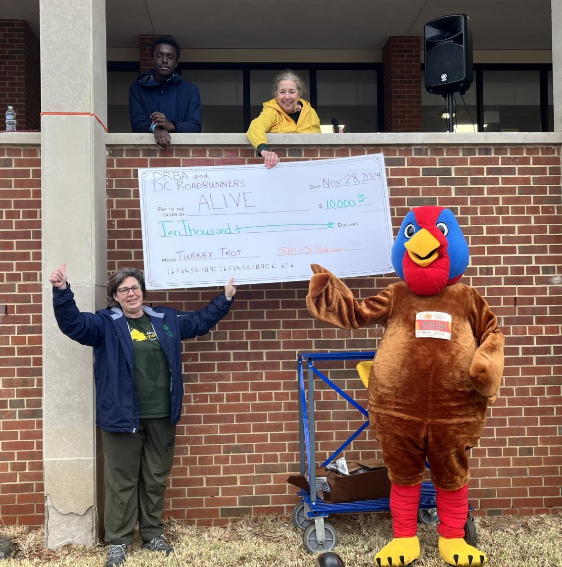 big turkey mascot holding a check with another lady