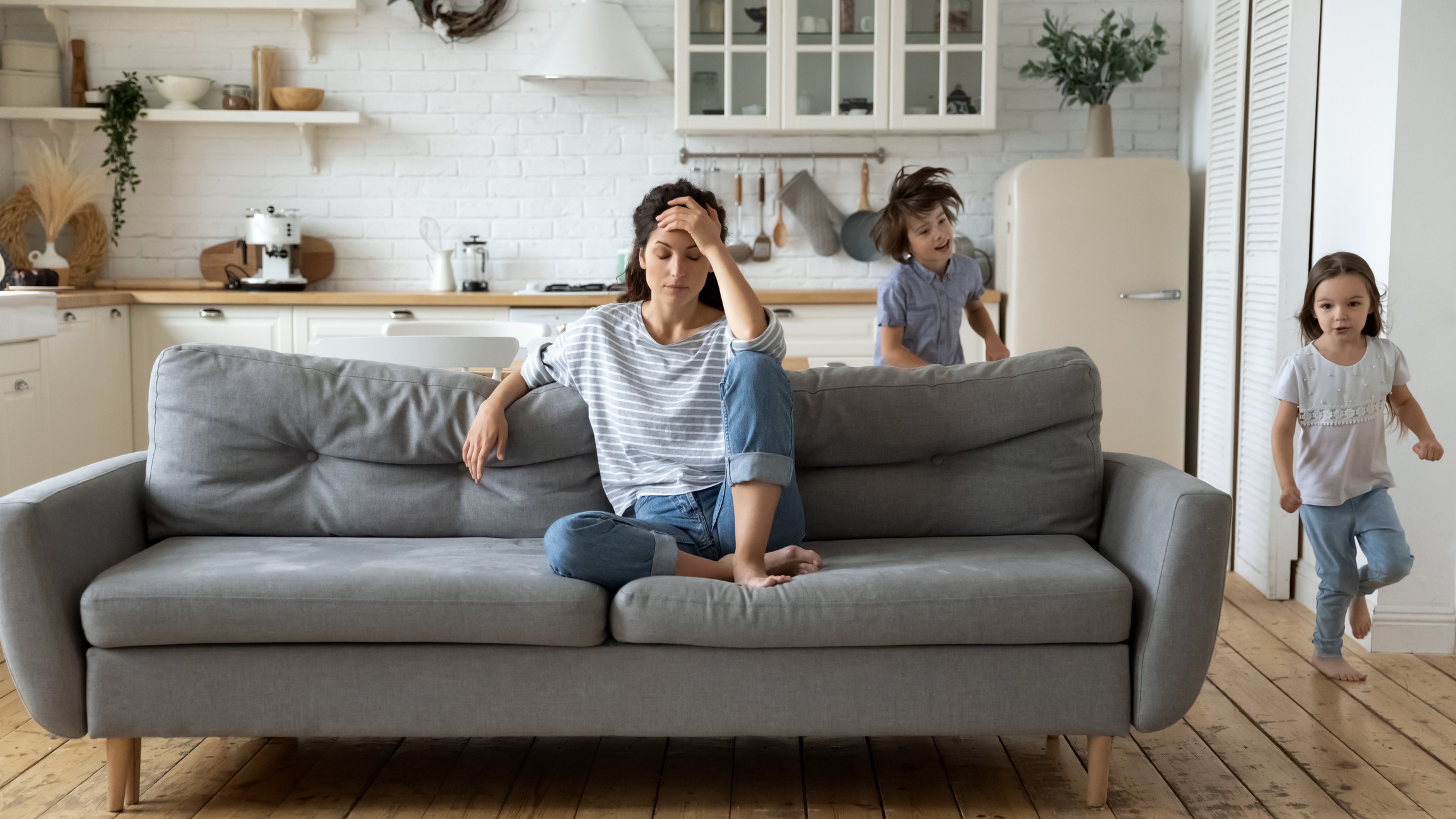 Exhausted young mother annoyed from loud children Exhausted young mother annoyed from loud children