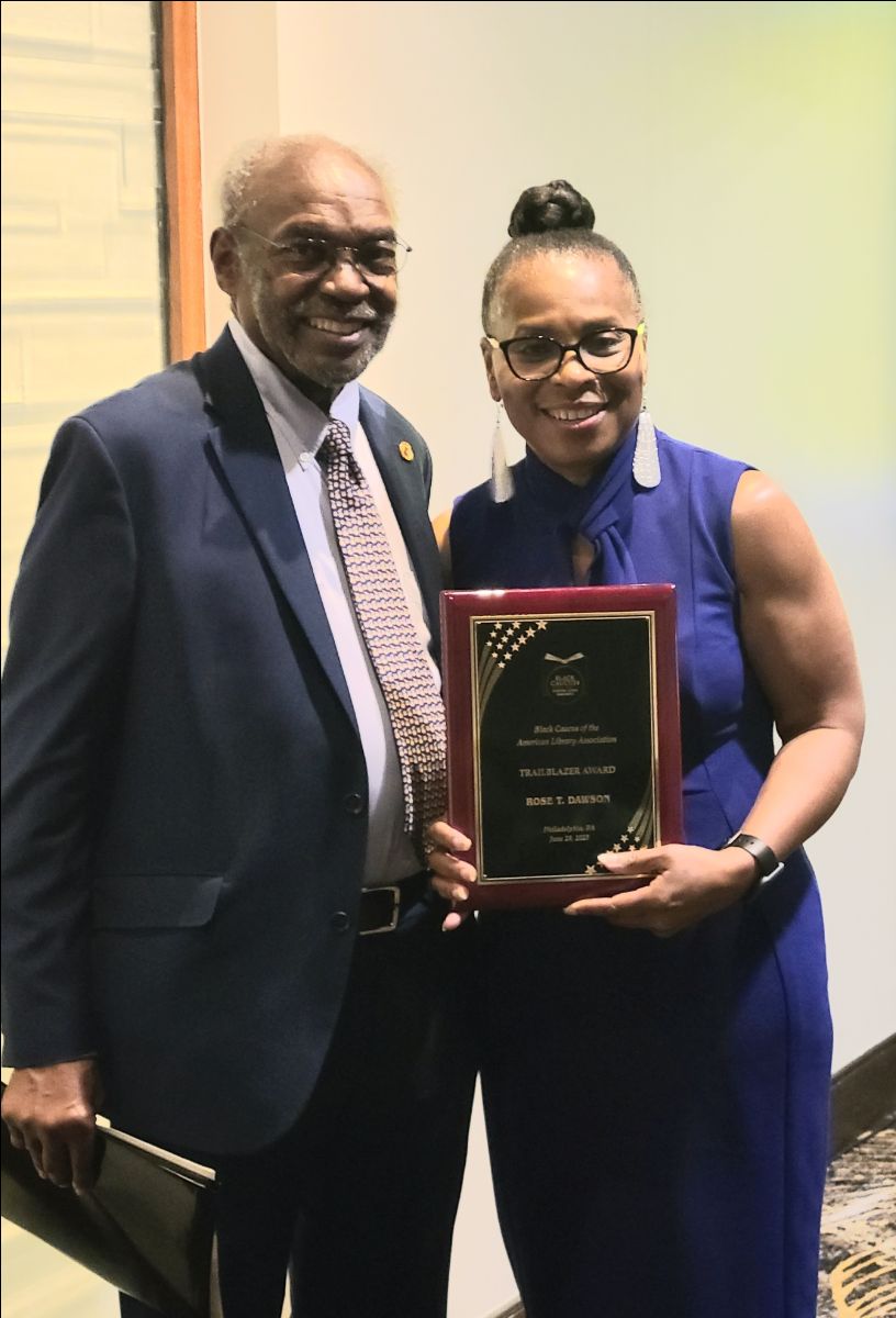 Rose Dawson ALX Library Man and woman standing next to each other with woman holding award.