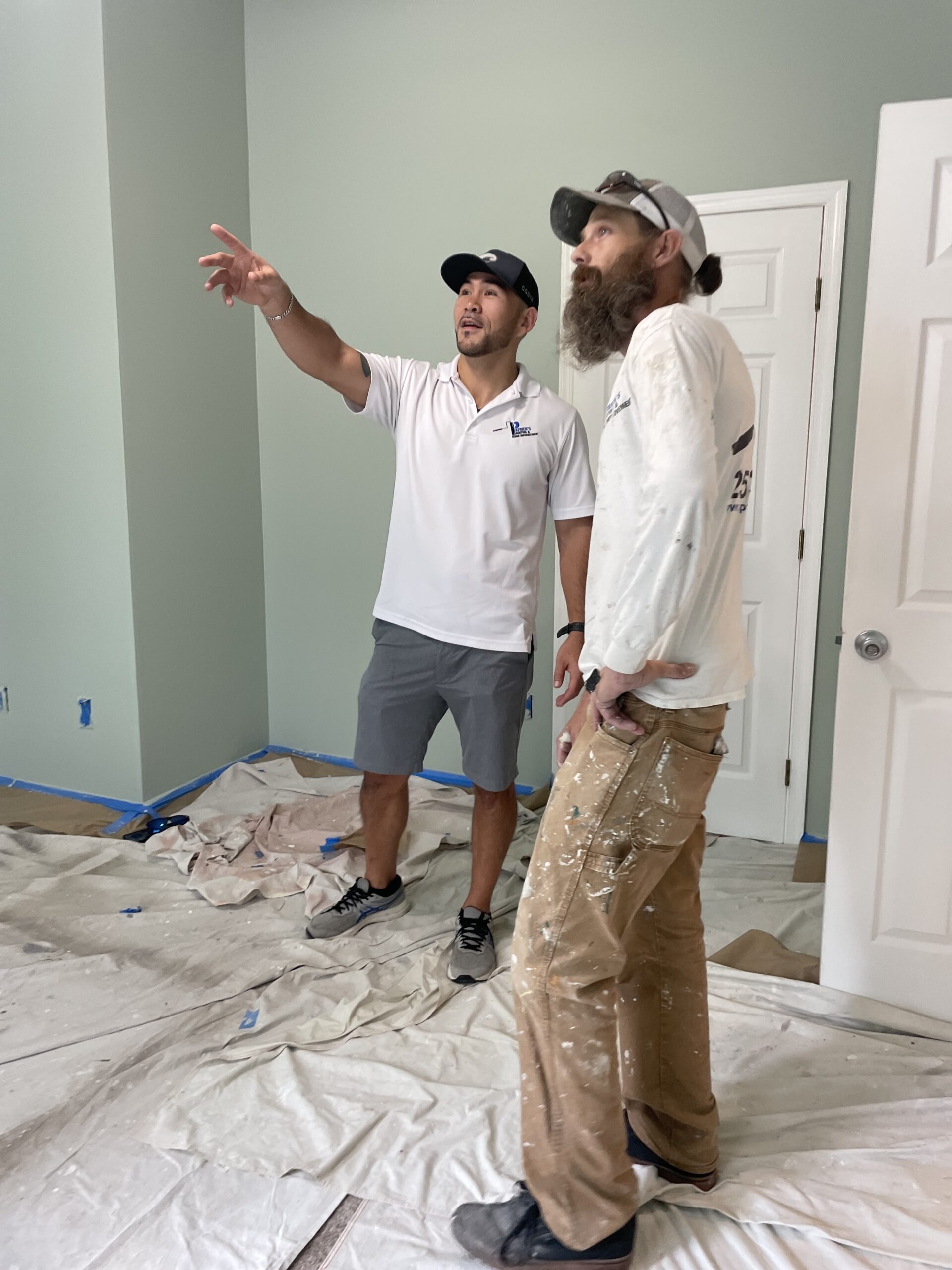 Patick Coye, left, inspects a jobsite in Kingstowne with painter Nick Pickering, a childhood friend and eight-year team member.