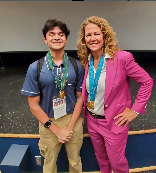 DDC with Michele Smith Olympic gold medalist Michele Smith, seen here with David De Costa, spoke to the students and allowed them to try on her medals.