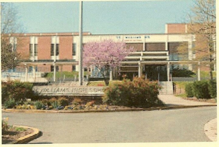 TC Williams OLD Front of brick building with sign that says TC Williams High School