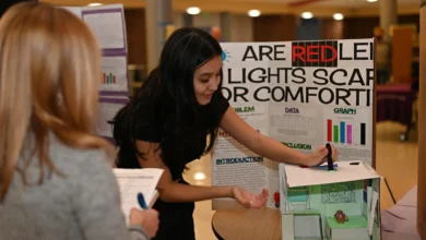 Young female student with dar hair is demonstrating her exhibit at Alexandria City Science Fair.