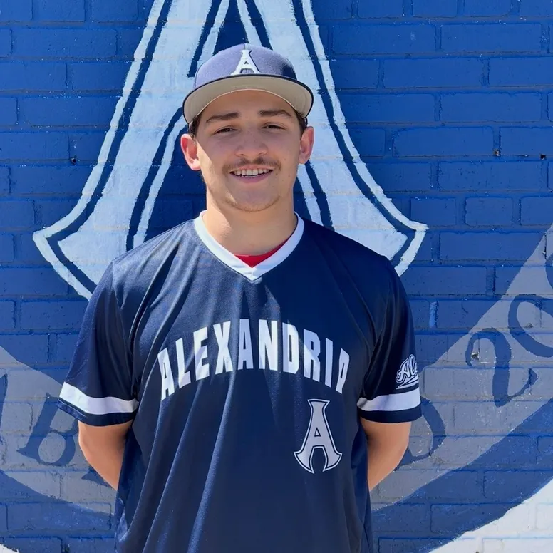 Noah Harvey Alexandria Aces Portrait of Alexandria Aces player Noah Harvey wearing a navy blue Aces jersey and cap while standing in front of a blue wall featuring the team's "A" logo. Harvey set a franchise record with eight RBIs in a 19-7 win over the D.C. Grays