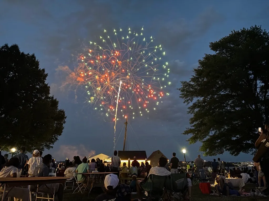 Families Watch Alexandria Fireworks Along the Potomac in ALexandria VA Families and friends gather on blankets and lawn chairs to watch fireworks during Alexandria's Birthday Celebration.