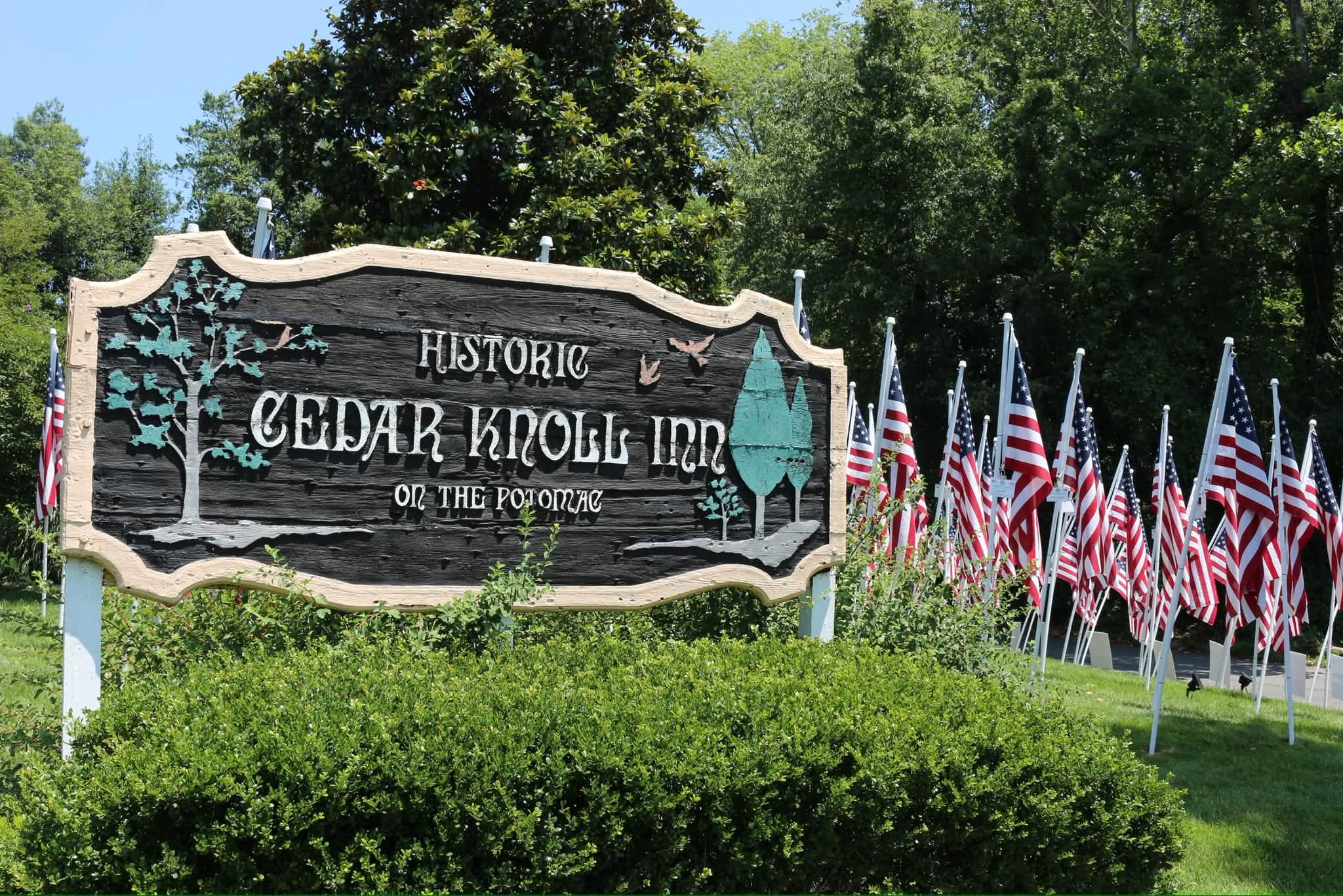 Historic Cedar Knoll Inn sign with American flags from the Rotary Club of Alexandria Flags for Heroes display in the background. Historic Cedar Knoll Inn sign with American flags from the Rotary Club of Alexandria Flags for Heroes display in the background.