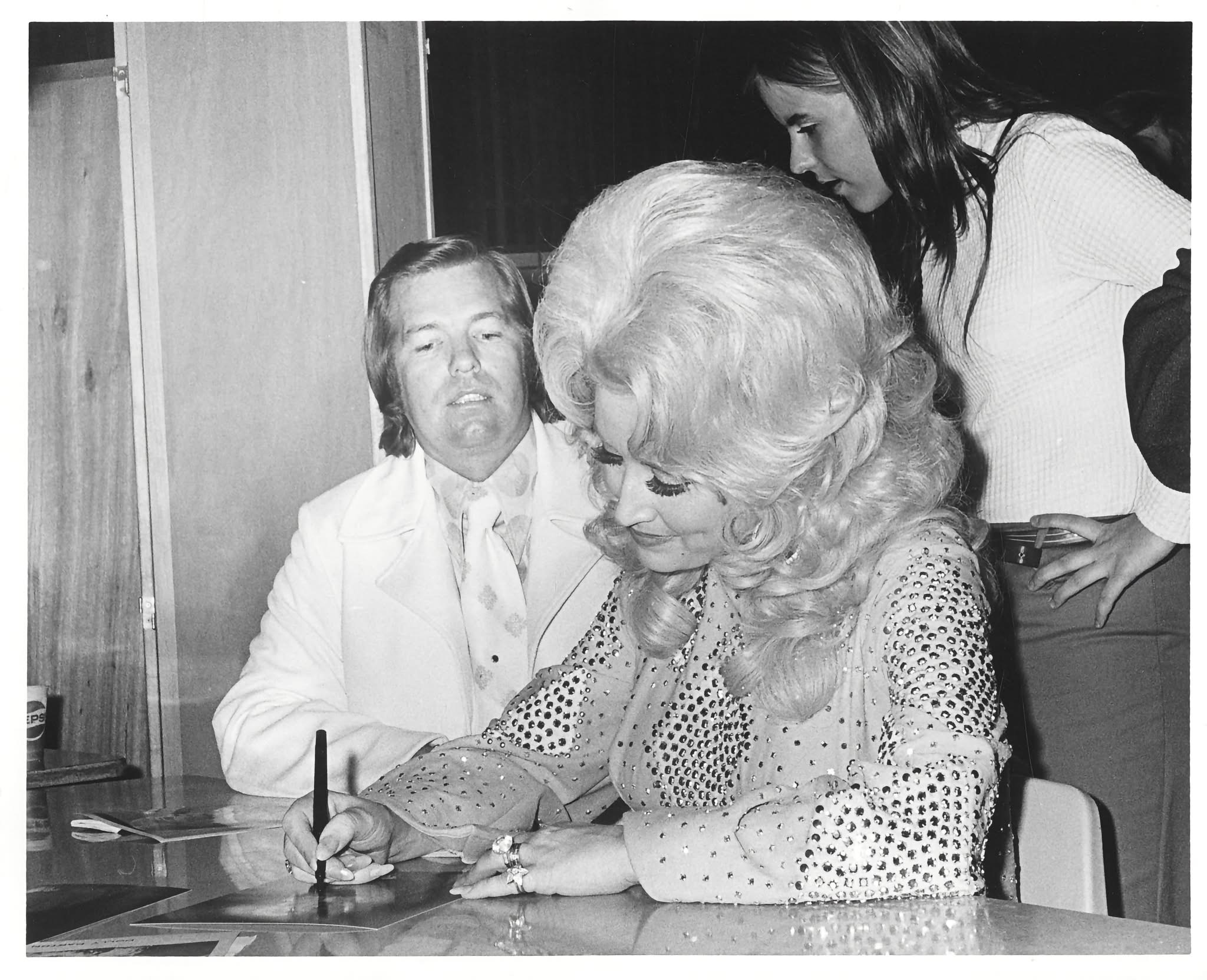 Dolly Parton Signs Autographs at Hayfield Dolly Parton signs an autograph as two people look on at Hayfield Secondary School in 1974.