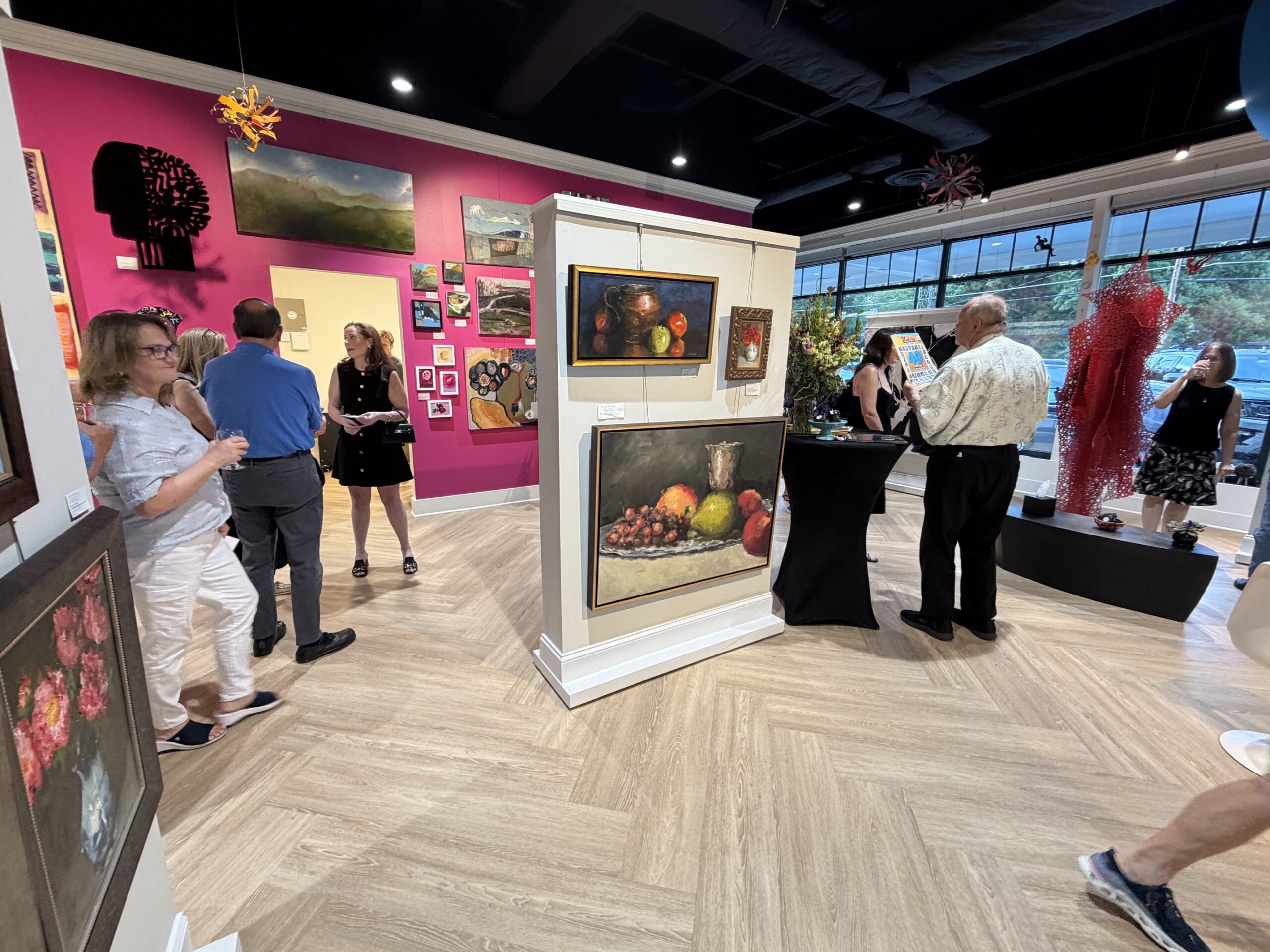 Guests mingle among the art during Nepenthe Gallery’s reopening celebration at its new Fort Hunt Road location. Photo: Susan Hahn. Guests visit Nepenthe Gallery during its reopening celebration, surrounded by paintings and sculpture.