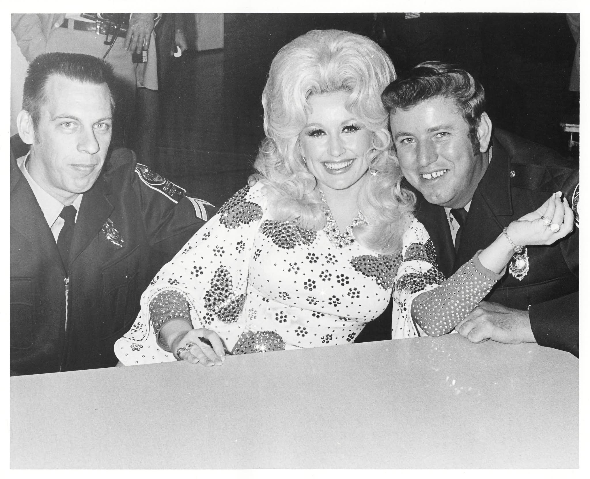 Dolly Parton at Hayfield Secondary School in 1974 Dolly Parton smiles between two uniformed men during her 1974 appearance at Hayfield Secondary School.