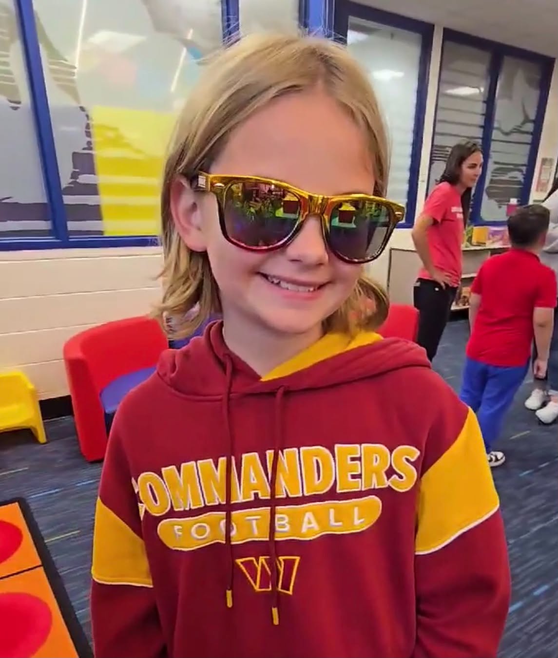 Fifth grader Maeve Mullarkey wears Washington Commanders gear and logo sunglasses at Mount Vernon Community School.