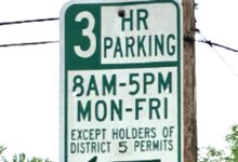 Green-and-white Alexandria parking sign reading “3 HR Parking, 8 a.m.–5 p.m., Monday–Friday, Except Holders of District 5 Permits.”