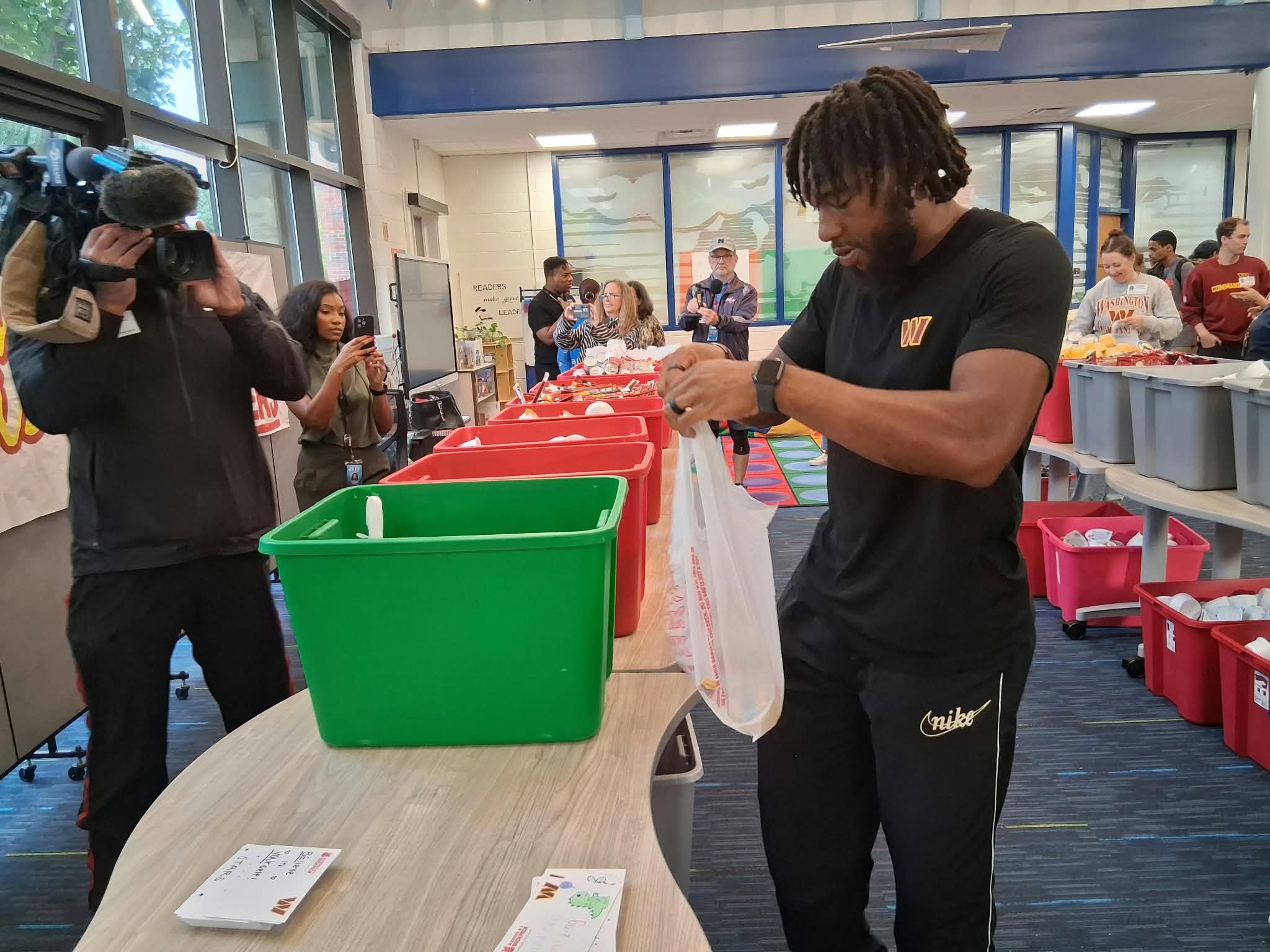 Washington Commanders wide receiver Jaylin Lane packs food bags at Mount Vernon Community School.
