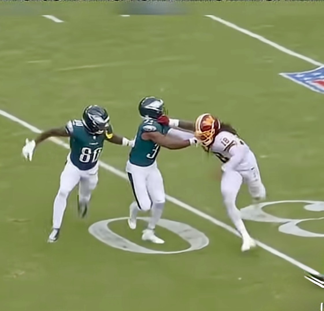 A Washington Commanders defender fights through two Philadelphia Eagles blockers during Sunday's game. (Photo: YouTube screenshot) Two Eagles players try to block Washington Commanders Darius Roberts.