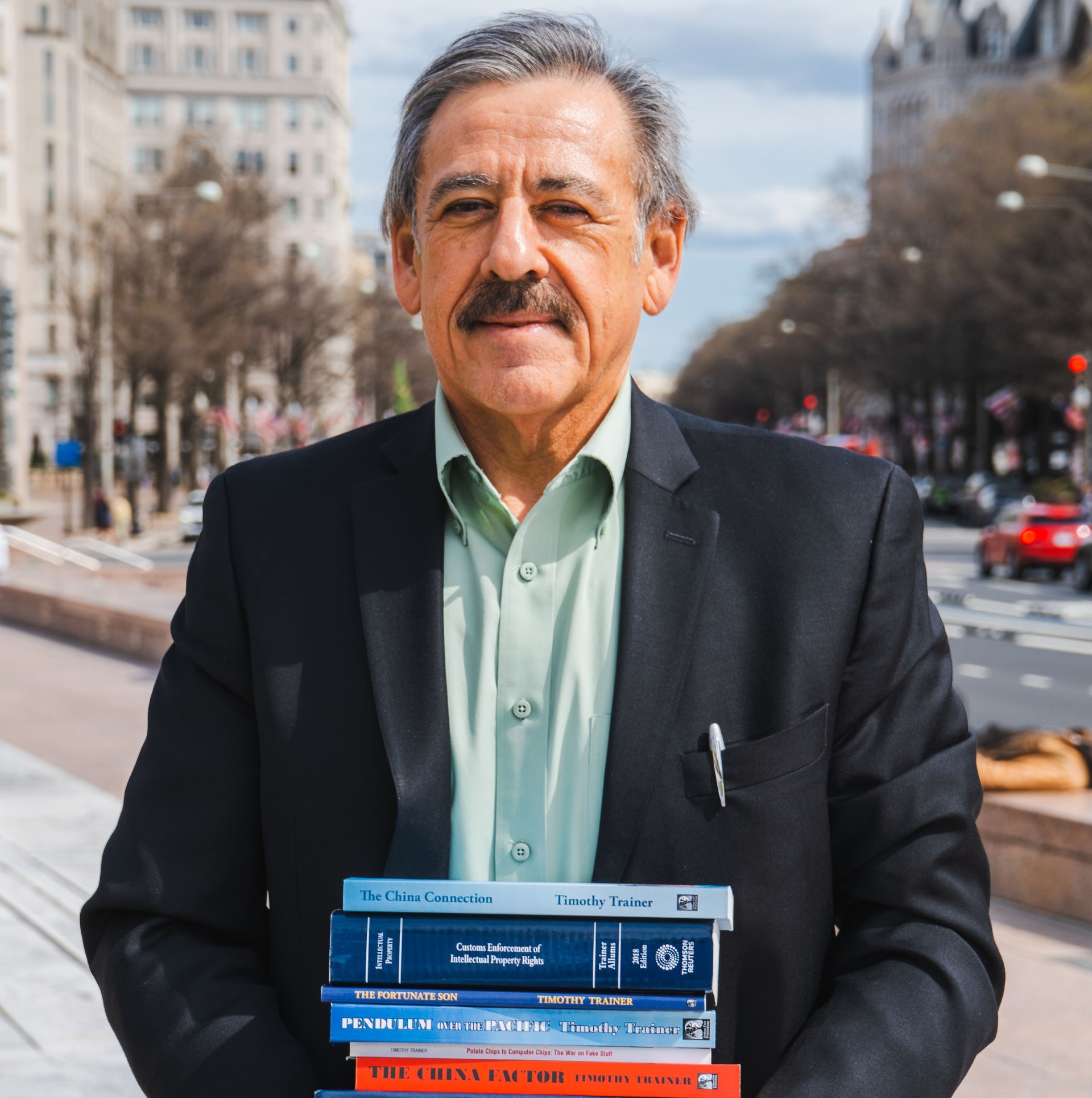 Author Timothy Trainer holding copies of his published books