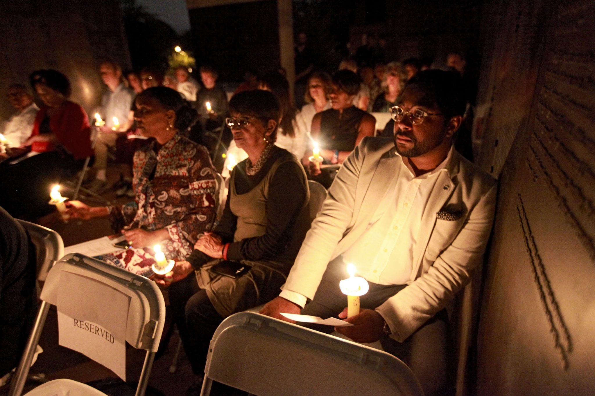 Community members hold candles at a 2019 vigil at Alexandria’s Contrabands and Freedmen Cemetery Memorial.