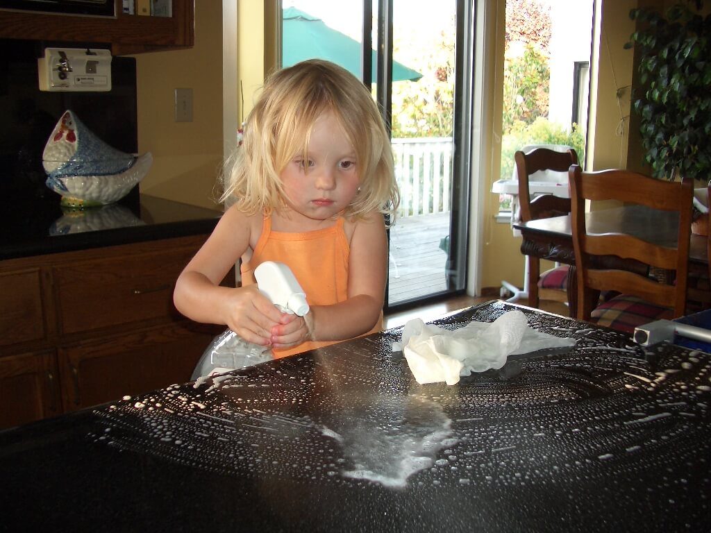 Lille pige rengører et spisebord