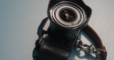 Picture of a Fujifilm X-S20 with the Fujifilm XF8mm F3.5 WR lens on a blue tabletop