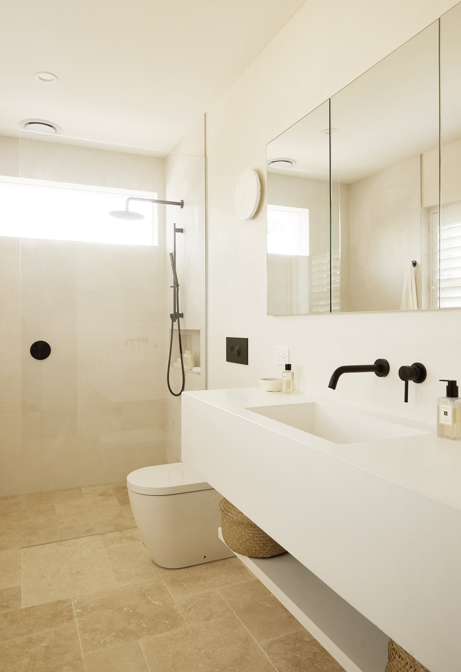 White Concrete sinks, black matte tapware, travertine tiles, Warm minimalist bathroom in Sydney