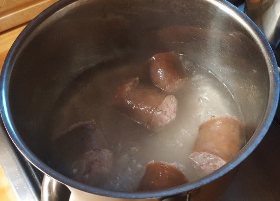 Die Wurststücke kochen, bis das Wasser verdampft ist