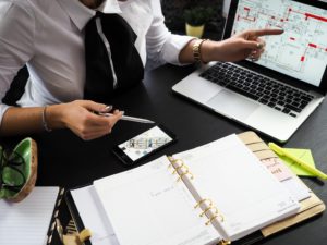 Person in business attire pointing to computer screen