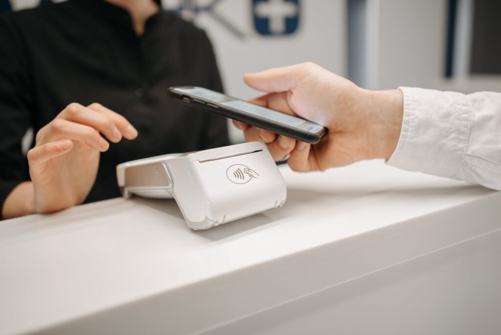 A stock image of someone paying for something using their phone, representing the sort of payment solution offered by a fintech in Mexico