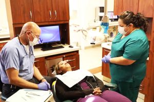 Dr. Eric Harrison and dental assistant Alisha Goins finish up with a dental patient.