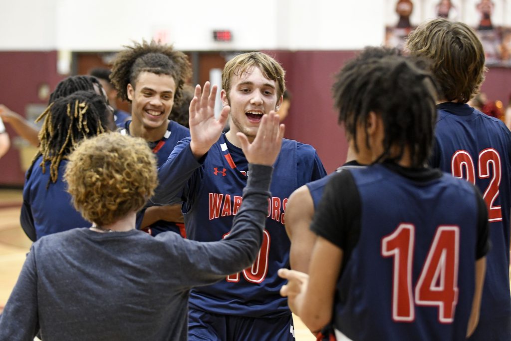 Senior shooting guard Landon Hall (2) is congratulated by teammates as he heads to the bench at the conclusion of Friday night’s game against William Byrd. Hall finished the night with 6 three-pointers for 18 points.