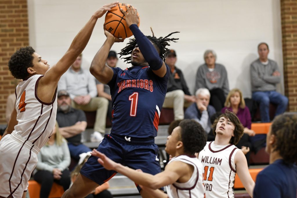 Magna Vista sophomore guard Simeon Moore (1) puts up a shot against William Byrd’s Israel Hairston Friday night in a first-round game of the VHSL Region 3D boys’ basketball tournament.