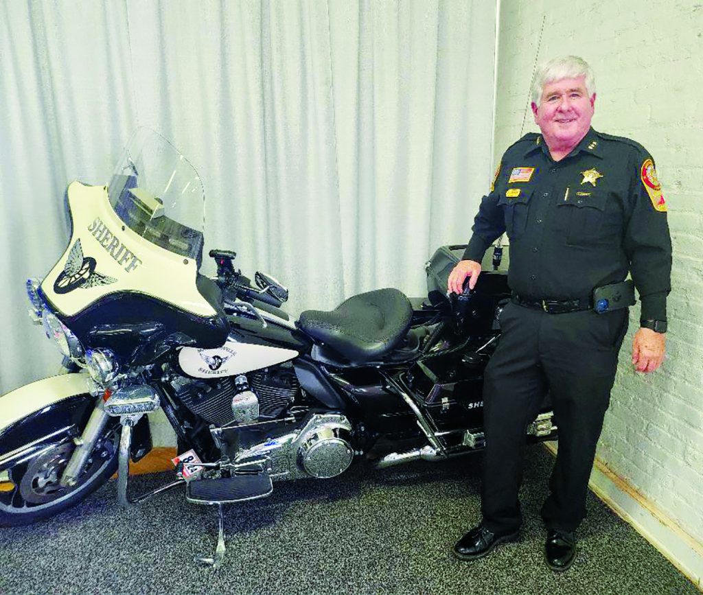 Martinsville Sheriff Stever Draper poses next to a Martinsville Sheriff’s Office motorcycle.