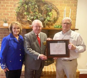 Ed Stephens (far right), General Manager of Collins-McKee-Stone Funeral Homes, presents an award to Don Robertson. Robertson’s wife, Gloria, is pictured by his side.