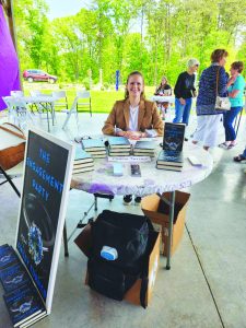 Finley Turner with several hardback copies of “The Engagement Party: a Novel.”