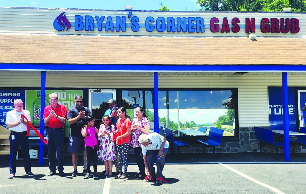 From left, Assistant County Administrator J.R. Powell and Jim Adams of the Reed Creek District, were among those attending a ribbon cutting ceremony at Bryan's Corner Gas N Grub. Adams and Powell as well as family and friends of new owner Bryan Patel, celebrated the milestone.