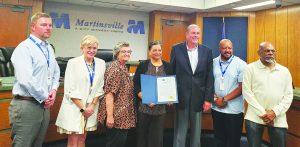 Officials from First Savings Bank were on hand as the agency was acknowledged for serving Martinsville for 100 years. From left, Vice Mayor Aaron Rawls and council members Tammy Pearson and Kathy Lawson flank representatives from the bank, along with Mayor LC Jones and council member Lawrence Mitchell.