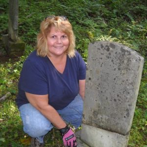 Beverly Belcher Woody is pictured next to the tombstone of her great-great-great grandmother. 