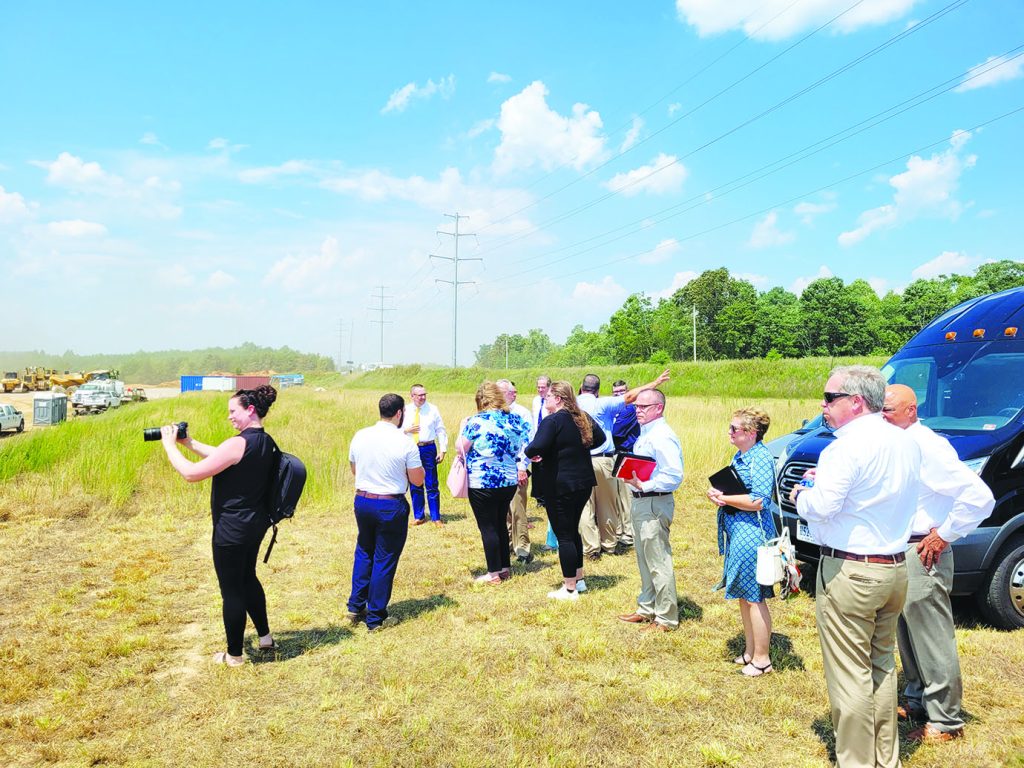 Local and other officials look on from the back side of Tract 2 as grading work continues.