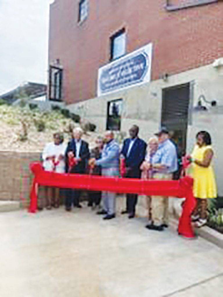 Several city officials celebrate the inauguration of the Fayette Street Lofts Building at 62 Fayette Street with a ribbon cutting.