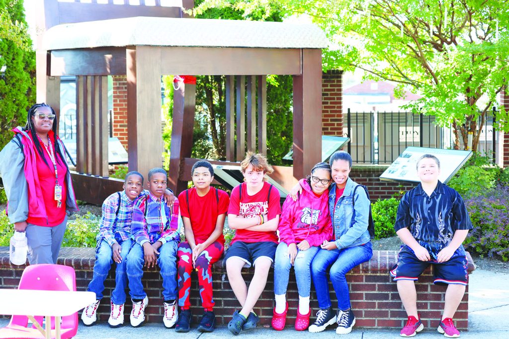 A group of middle school students take a break in front of the iconic ‘Big Chair.’