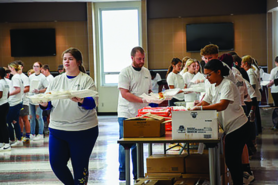 Volunteers pack meals to be served and delivered at the 2023 W. Dan Prince III Thanksgiving Eve Dinner.