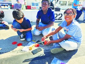 Patrick Henry Elementary School students focus on building rubber band-powered race cars.