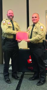 Lt. M. Duffy (left) presents the award to Justin Jones.