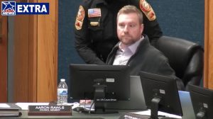 A police officer prepared to escort Martinsville City Council member Aaron Rawls from the dais at Tuesday’s meeting. (Courtesy of STAR NEWS)