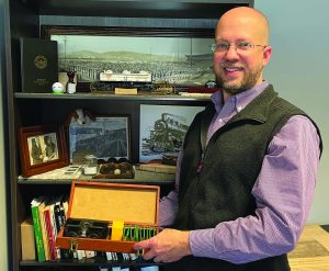 Andrew Doss holds pieces of Bassett Furniture history in his hands.