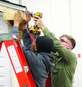 Students in Jerry Byrd’s carpentry class put the finishing touches on a storage shed.