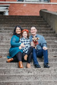 A lifelong resident of Shinnston, Citizen of the Month Pat Boggess joins his wife Whitney, daughter Giada and dog Kiki on the steps of the former Shinnston High School. 